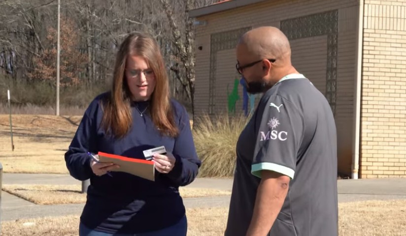 A woman from Huntsville Animal Services takes down information from a man during a community pet event
