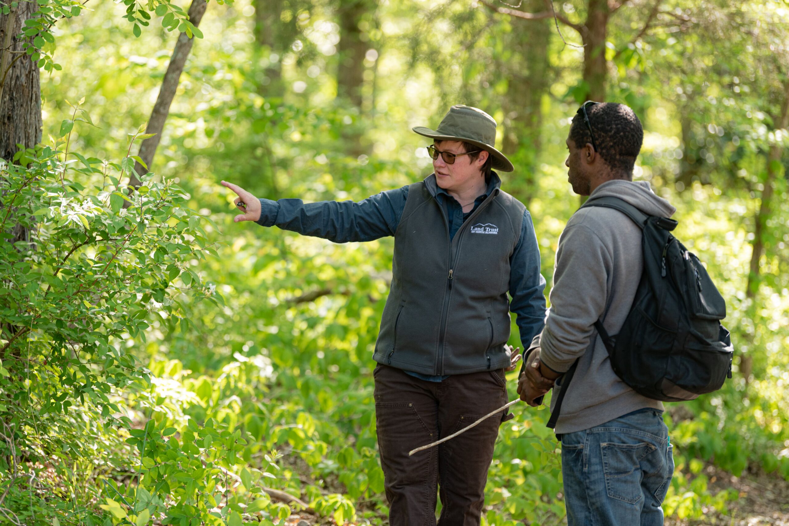 A man and a woman discuss how to remove an invasive plant