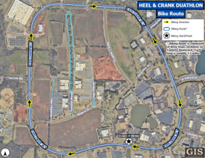 An aerial map displays the bike route for the Heel & Crank Duathlon. The course is marked with a blue line and yellow arrows showing the biking direction. The route follows a large clockwise loop around Explorer Boulevard, passing areas labeled Explorer Blvd, Farrow Road, Bradford Drive, and Enterprise Way. A star icon marks the start and finish location near the lower center of the map. A legend explains the biking direction, route markings, and the start/finish symbol. Text notes that the biking route consists of three loops on Explorer Boulevard, each approximately 3.7 miles. GIS City of Huntsville branding appears in the bottom right corner.