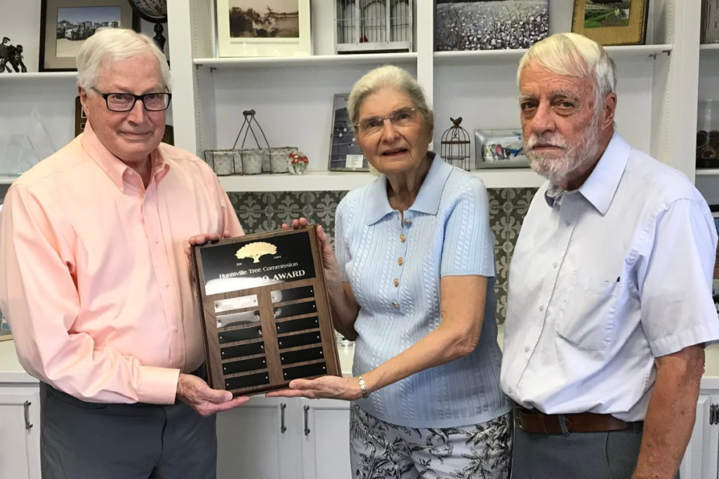 John Allen accepts the City's Tree Hero plaque from two members of the Huntsville Tree Commission