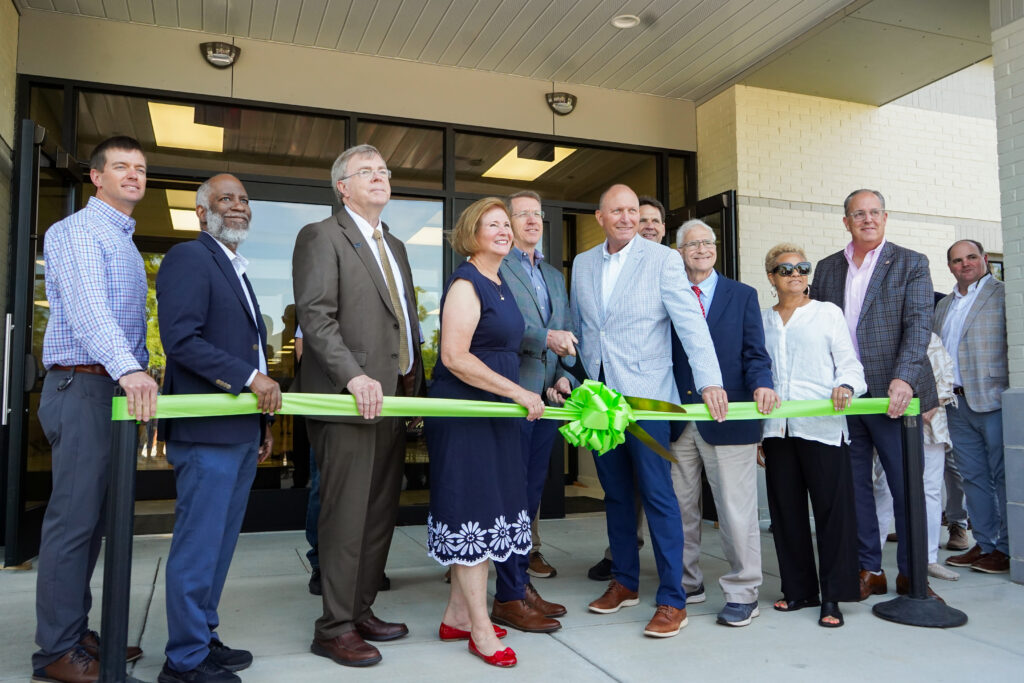 A group of people cutting a ceremonial ribbon