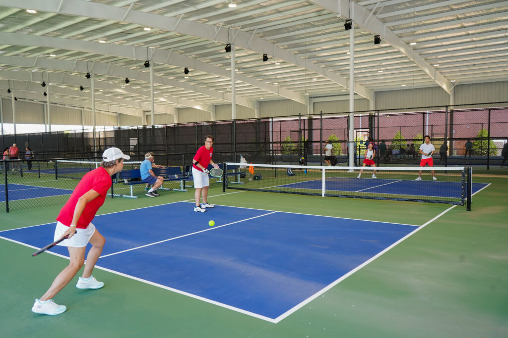 A group of people playing pickleball.