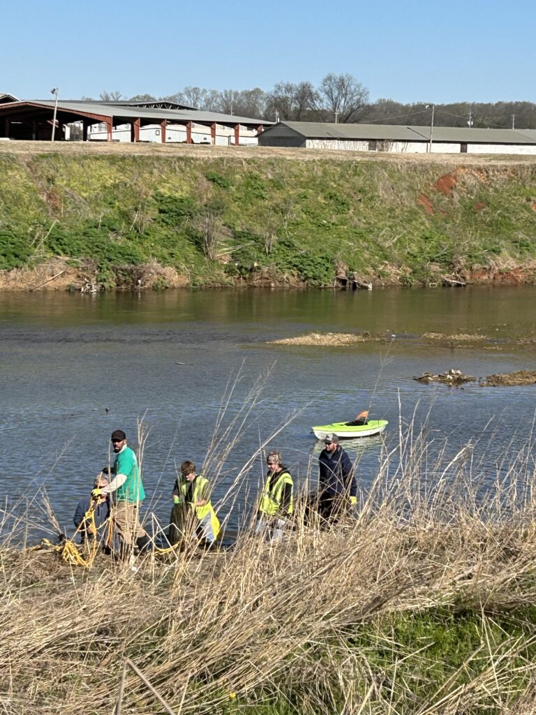 Volunteers collecting trash along a river