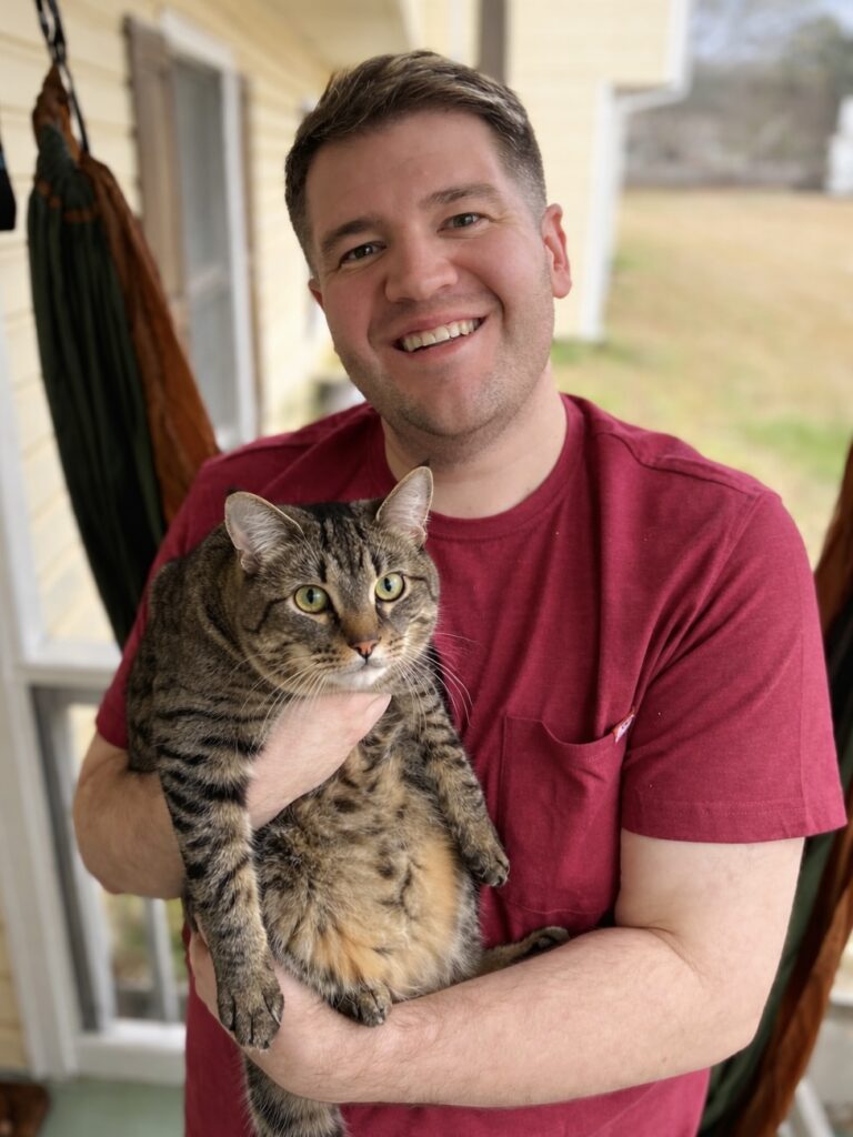 Beautification Board Member Zach Hester holding his striped brown and black cat