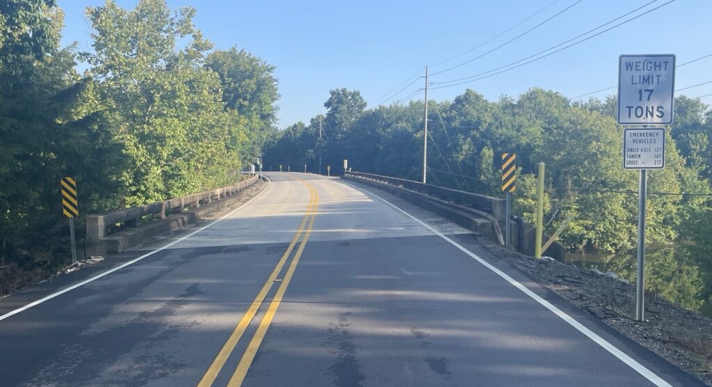 bridge on two-lane road with trees on both sides